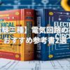 電験三種の電気回路の基礎を学べる参考書2冊。図面や工具と一緒に写された教材の写真。